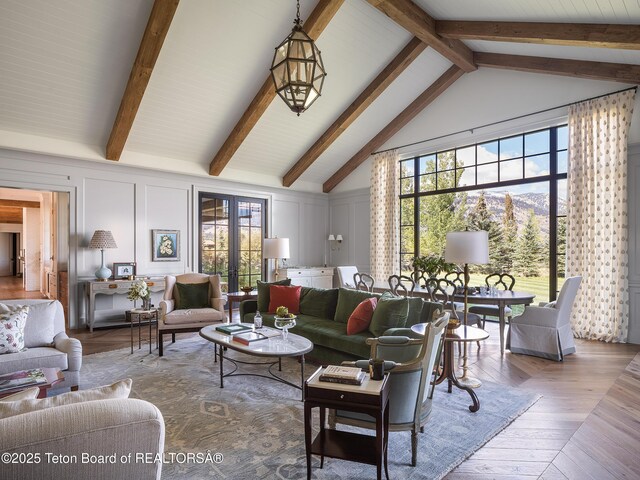 5025 Shoshone Dr, Wilson, WY 83014 - living room with beam ceiling, a decorative wall, wood finished floors, and high vaulted ceiling