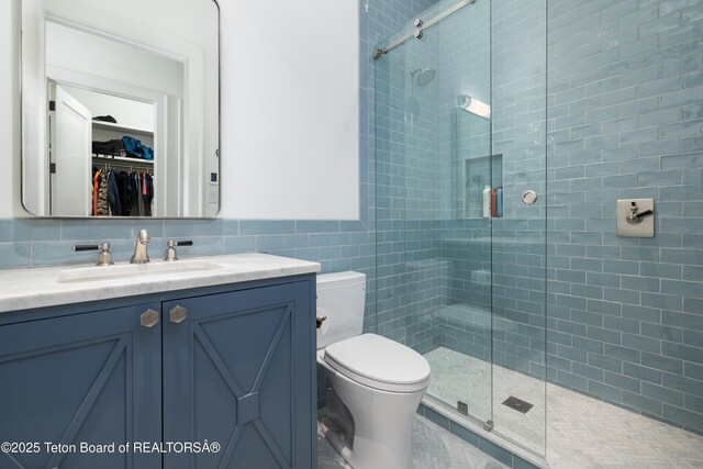 5025 Shoshone Dr, Wilson, WY 83014 - full bath with tile walls, vanity, a shower stall, and a walk in closet