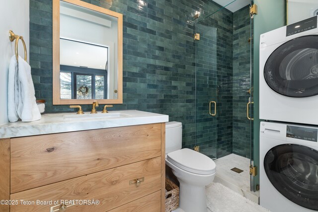 5025 Shoshone Dr, Wilson, WY 83014 - full bath featuring estacked washer and dryer, vanity, tile walls, and a stall shower