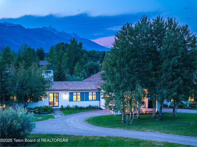 5025 Shoshone Dr, Wilson, WY 83014 - view of front of property featuring a mountain view, a lawn, and curved driveway