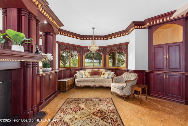 1255 Lost Crk, Thayne, WY 83127 - living room featuring healthy amount of natural light, a chandelier, crown molding, wainscoting, and a decorative wall