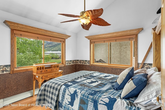 1255 Lost Crk, Thayne, WY 83127 - bedroom with lofted ceiling, a baseboard radiator, wood finished floors, and ceiling fan