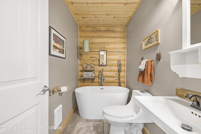 105 Elk Path, Swan Valley, ID 83428 - bathroom with wood ceiling, a freestanding bath, a sink, rustic walls, and baseboards