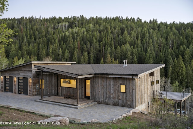 5170 Meandering Moose Dr, Victor, ID 83455 - modern home with a wooded view and roof with shingles