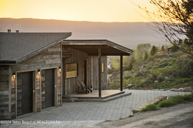 5170 Meandering Moose Dr, Victor, ID 83455 - doorway to property featuring roof with shingles and a garage
