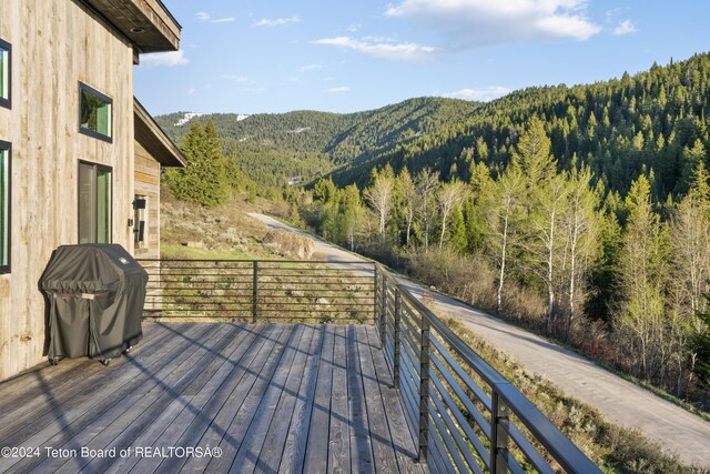 5170 Meandering Moose Dr, Victor, ID 83455 - deck featuring a mountain view, a view of trees, and grilling area