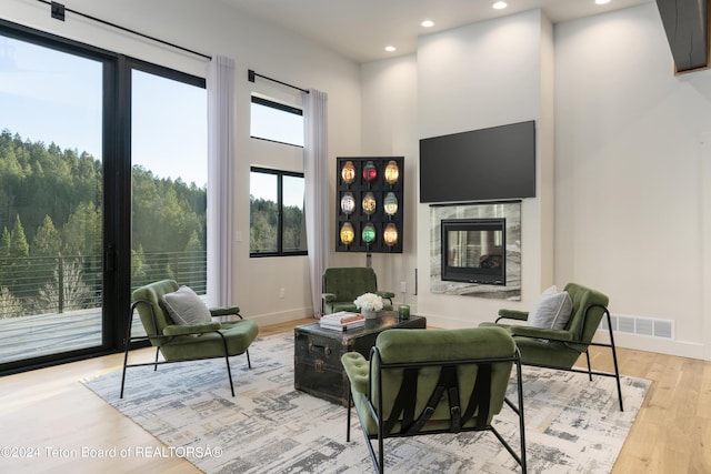 5170 Meandering Moose Dr, Victor, ID 83455 - living area featuring recessed lighting, a high end fireplace, light wood finished floors, a high ceiling, and baseboards