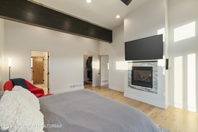5170 Meandering Moose Dr, Victor, ID 83455 - bedroom featuring wood finished floors, a glass covered fireplace, baseboards, recessed lighting, and a spacious closet
