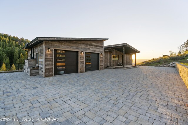 5170 Meandering Moose Dr, Victor, ID 83455 - garage at dusk with decorative driveway