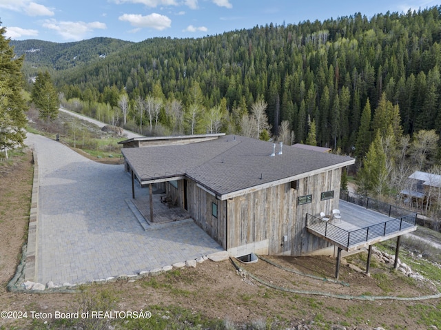 5170 Meandering Moose Dr, Victor, ID 83455 - view from above of property with a heavily wooded area and a mountain backdrop