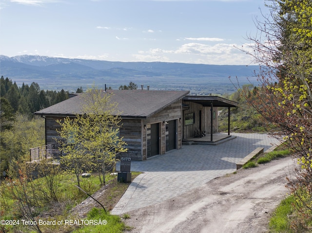 5170 Meandering Moose Dr, Victor, ID 83455 - modern home with decorative driveway, a mountain view, and a garage