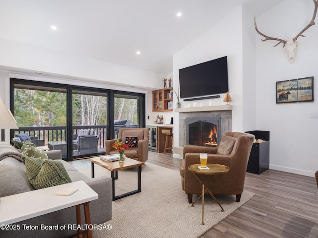 7280 N Rachel Way Unit B-7, Teton Village, WY 83025 - living area featuring a lit fireplace, wood finished floors, recessed lighting, baseboards, and high vaulted ceiling