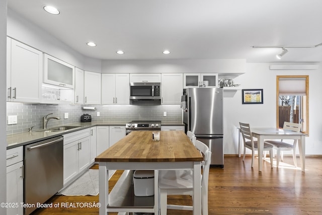 207 W Snow King Ave, Jackson, WY 83001 - kitchen featuring stainless steel appliances, a sink, butcher block counters, backsplash, and white cabinetry