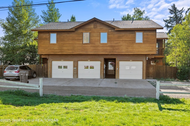 207 W Snow King Ave, Jackson, WY 83001 - rustic home featuring an attached garage, roof with shingles, and concrete driveway