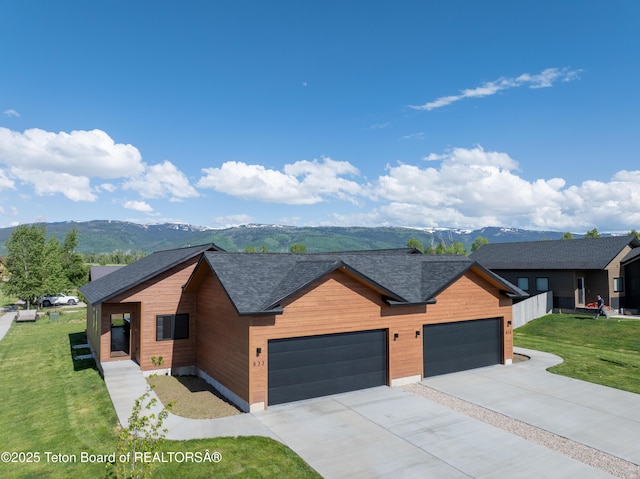 833 Booshway St, Driggs, ID 83422 - modern home with an attached garage, driveway, a front lawn, and a mountain view