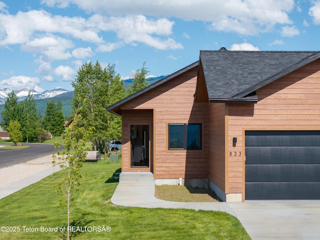 833 Booshway St, Driggs, ID 83422 - view of front of property with a mountain view, a garage, roof with shingles, a front yard, and driveway