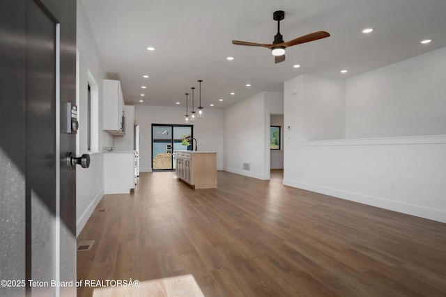 833 Booshway St, Driggs, ID 83422 - unfurnished living room featuring wood finished floors, a ceiling fan, recessed lighting, baseboards, and a sink