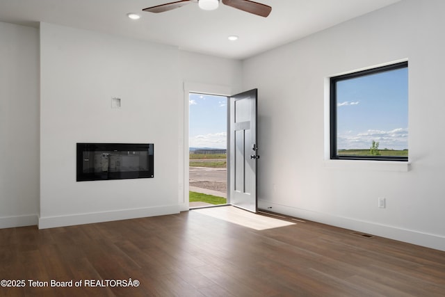 833 Booshway St, Driggs, ID 83422 - unfurnished living room featuring wood finished floors, ceiling fan, a glass covered fireplace, baseboards, and recessed lighting
