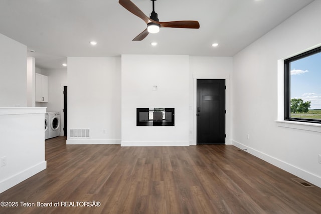 833 Booshway St, Driggs, ID 83422 - unfurnished living room with washer and clothes dryer, ceiling fan, a glass covered fireplace, dark wood-type flooring, and recessed lighting