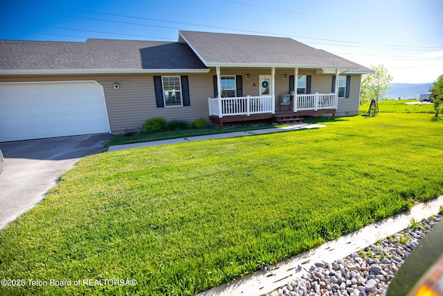 28 Brushwood Dr, Star Valley Ranch, WY 83127 - view of front facade featuring covered porch, asphalt driveway, an attached garage, a front yard, and a shingled roof