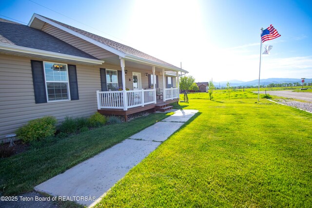 28 Brushwood Dr, Star Valley Ranch, WY 83127 - view of home's exterior with a porch, a shingled roof, a lawn, and a mountain view
