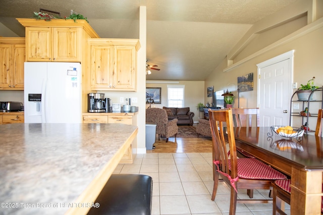 28 Brushwood Dr, Star Valley Ranch, WY 83127 - kitchen with white fridge with ice dispenser, lofted ceiling, ceiling fan, light tile patterned floors, and light brown cabinetry