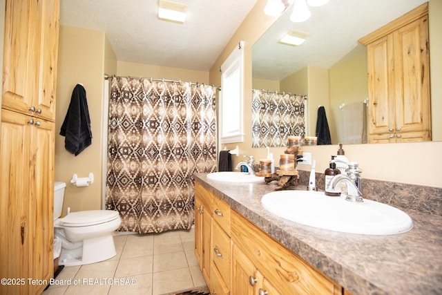 28 Brushwood Dr, Star Valley Ranch, WY 83127 - bathroom featuring toilet, double vanity, tile patterned floors, a shower with shower curtain, and a textured ceiling