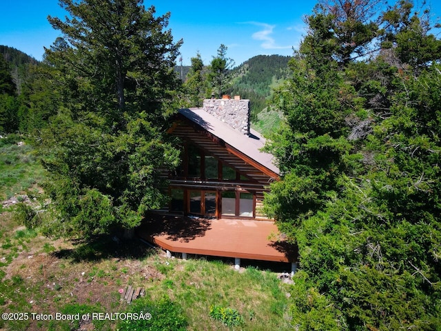 3392 Bainbridge Dr, Tetonia, ID 83452 - back of house with a deck with mountain view, a chimney, and a view of trees