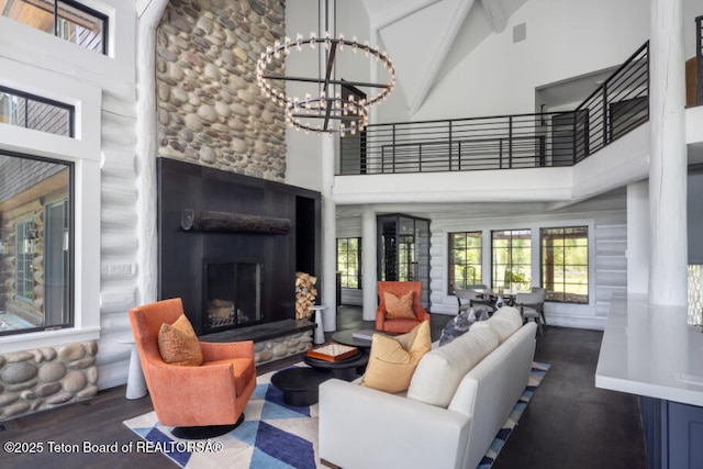 185 S Swan Rd, Jackson, WY 83001 - living area featuring high vaulted ceiling, a chandelier, wood finished floors, a fireplace with raised hearth, and beam ceiling