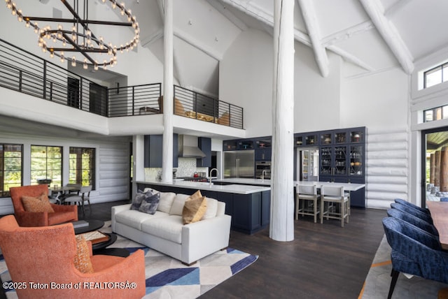 185 S Swan Rd, Jackson, WY 83001 - living room with high vaulted ceiling, dark wood finished floors, beamed ceiling, a chandelier, and decorative columns