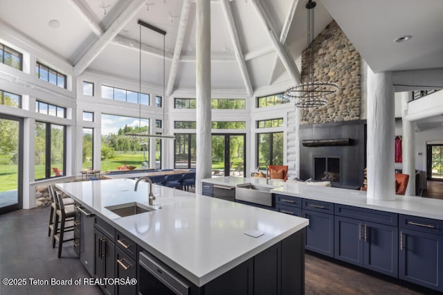 185 S Swan Rd, Jackson, WY 83001 - kitchen with an island with sink, plenty of natural light, a large fireplace, open floor plan, and beam ceiling