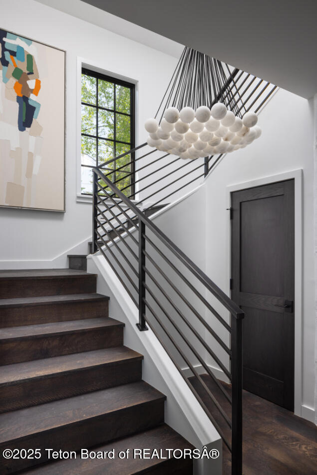 185 S Swan Rd, Jackson, WY 83001 - stairway with a chandelier and wood finished floors