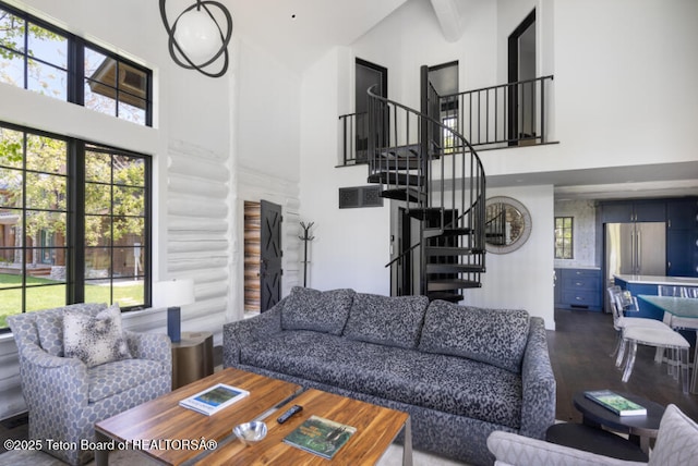 185 S Swan Rd, Jackson, WY 83001 - living area with a high ceiling, stairs, log walls, healthy amount of natural light, and wood finished floors
