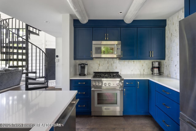 185 S Swan Rd, Jackson, WY 83001 - kitchen with stainless steel appliances, blue cabinets, beam ceiling, light countertops, and dark wood finished floors