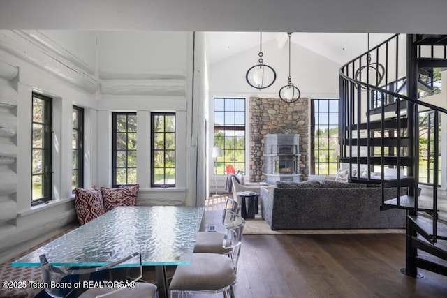 185 S Swan Rd, Jackson, WY 83001 - dining area with dark wood-style floors, healthy amount of natural light, a fireplace, stairs, and high vaulted ceiling