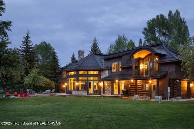 185 S Swan Rd, Jackson, WY 83001 - back of property featuring a balcony, a chimney, a lawn, a standing seam roof, and stone siding