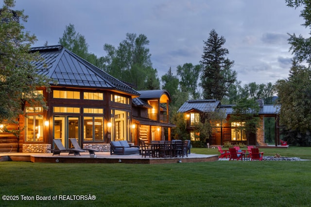 185 S Swan Rd, Jackson, WY 83001 - back of property featuring a standing seam roof, a yard, a metal roof, a patio area, and stone siding