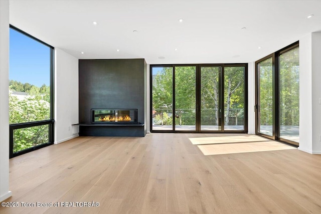 80 Rancher St, Jackson, WY 83001 - unfurnished living room with floor to ceiling windows, a fireplace, and wood finished floors