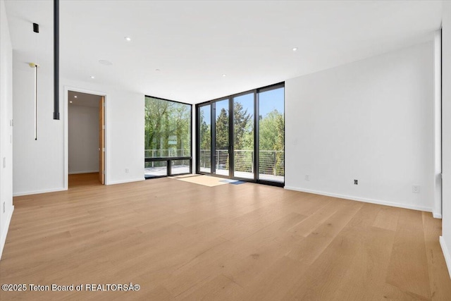 80 Rancher St, Jackson, WY 83001 - empty room featuring a wall of windows, light wood-style flooring, baseboards, and recessed lighting