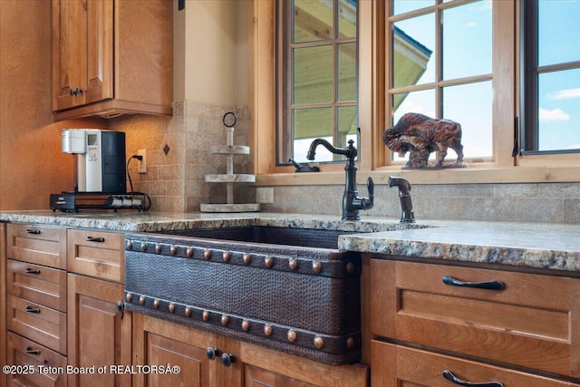 2321 S 3500 W, Driggs, ID 83422 - kitchen with brown cabinetry, decorative backsplash, and stone counters