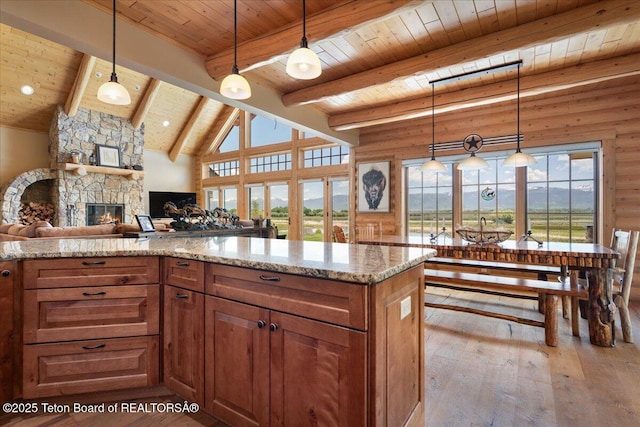 2321 S 3500 W, Driggs, ID 83422 - kitchen featuring wood ceiling, hardwood / wood-style floors, brown cabinets, light stone counters, and a stone fireplace