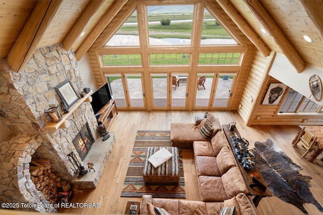 2321 S 3500 W, Driggs, ID 83422 - living area with a stone fireplace, wood-type flooring, healthy amount of natural light, high vaulted ceiling, and a wooden ceiling with exposed beams