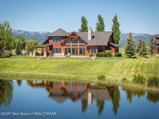 2321 S 3500 W, Driggs, ID 83422 - back of property with a chimney, a yard, a water and mountain view, and board and batten siding