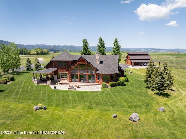2321 S 3500 W, Driggs, ID 83422 - back of property featuring a patio area, a lawn, a chimney, a carport, and a mountain view
