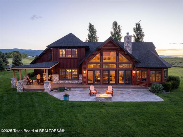 2321 S 3500 W, Driggs, ID 83422 - rear view of house featuring a patio area, a fire pit, a chimney, and a lawn