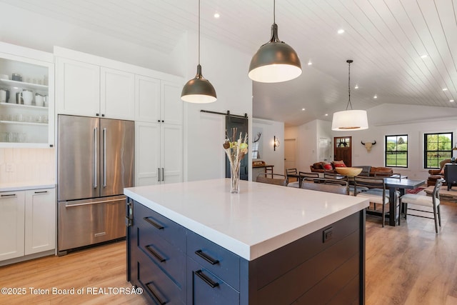 4326 State Line Rd, Freedom, WY 83120 - kitchen with high end refrigerator, a barn door, vaulted ceiling, open floor plan, and light wood-style floors