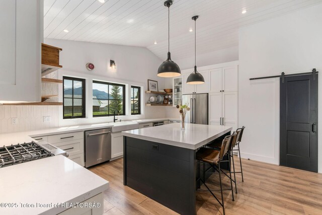 4326 State Line Rd, Freedom, WY 83120 - kitchen with open shelves, stainless steel appliances, lofted ceiling, light countertops, and white cabinetry