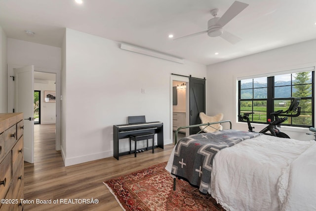 4326 State Line Rd, Freedom, WY 83120 - bedroom with a barn door, recessed lighting, light wood-type flooring, ensuite bathroom, and a ceiling fan