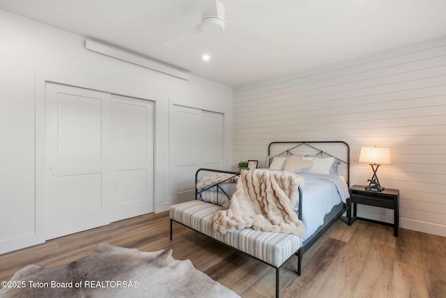 4326 State Line Rd, Freedom, WY 83120 - bedroom featuring wood finished floors, a ceiling fan, wooden walls, multiple closets, and recessed lighting
