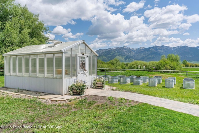 4326 State Line Rd, Freedom, WY 83120 - view of side of property featuring a greenhouse, an outdoor structure, a mountain view, and a garden